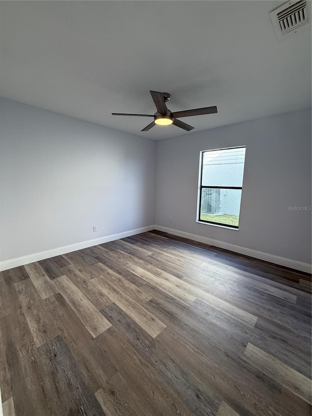 spare room featuring dark wood-type flooring and ceiling fan