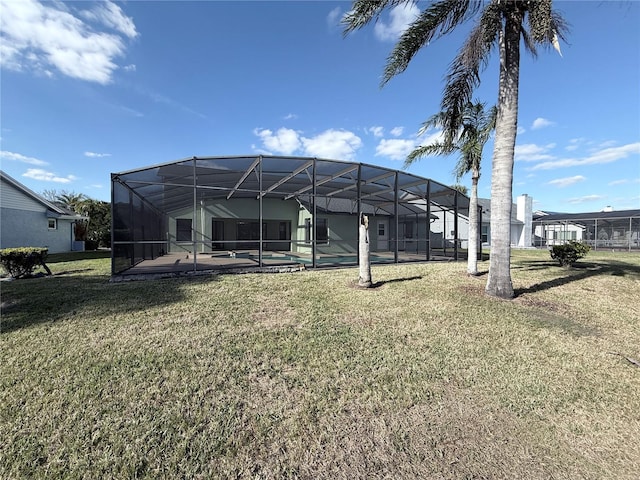 rear view of house with a lanai and a lawn