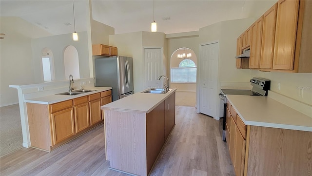 kitchen with pendant lighting, sink, stainless steel appliances, and an island with sink