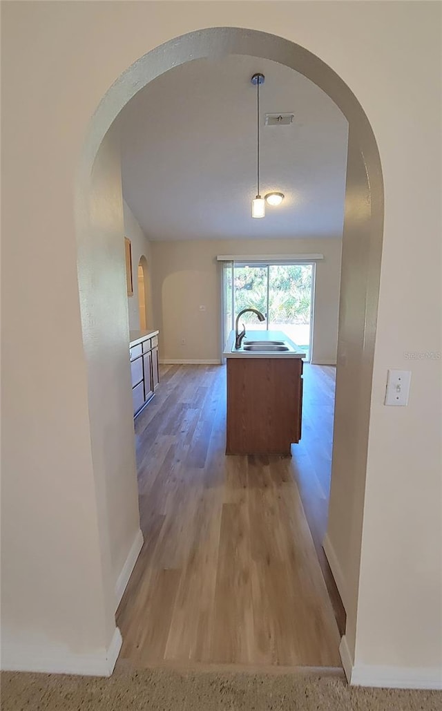 corridor featuring sink and light wood-type flooring