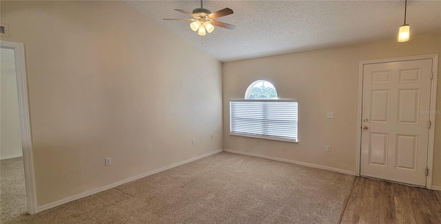 carpeted spare room with ceiling fan and a textured ceiling