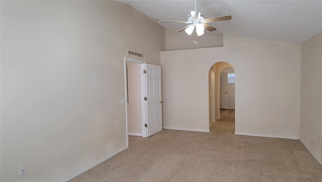 carpeted spare room featuring ceiling fan, high vaulted ceiling, and a textured ceiling