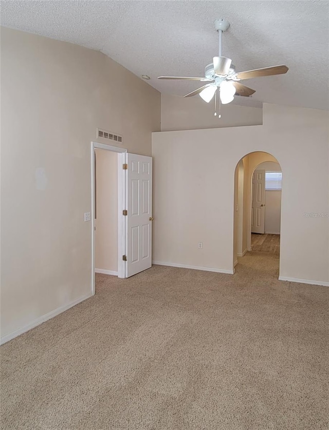 unfurnished room with ceiling fan, light colored carpet, lofted ceiling, and a textured ceiling