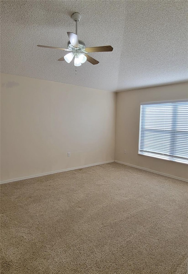 spare room with a textured ceiling, ceiling fan, and carpet