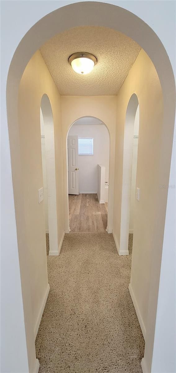 hallway with a textured ceiling