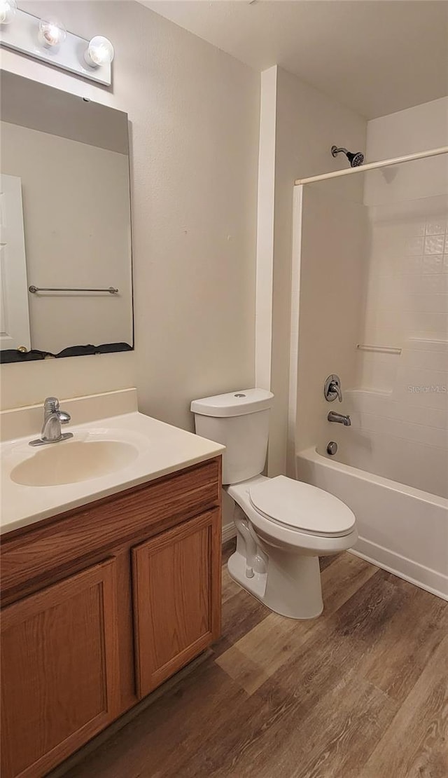 full bathroom featuring hardwood / wood-style flooring, shower / bathtub combination, vanity, and toilet