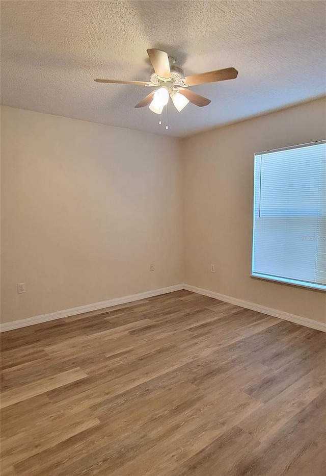 spare room featuring hardwood / wood-style flooring, ceiling fan, and a textured ceiling