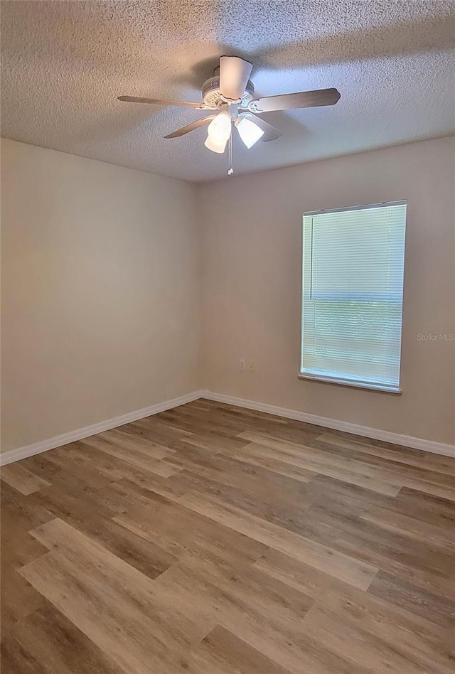 unfurnished room with ceiling fan, hardwood / wood-style flooring, and a textured ceiling