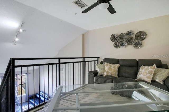 living room featuring vaulted ceiling, rail lighting, and ceiling fan