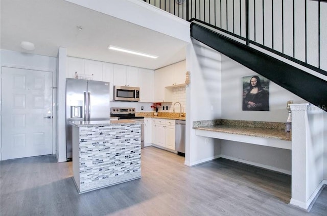 kitchen featuring white cabinetry, sink, stainless steel appliances, and light wood-type flooring