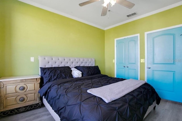 bedroom with crown molding, wood-type flooring, and ceiling fan