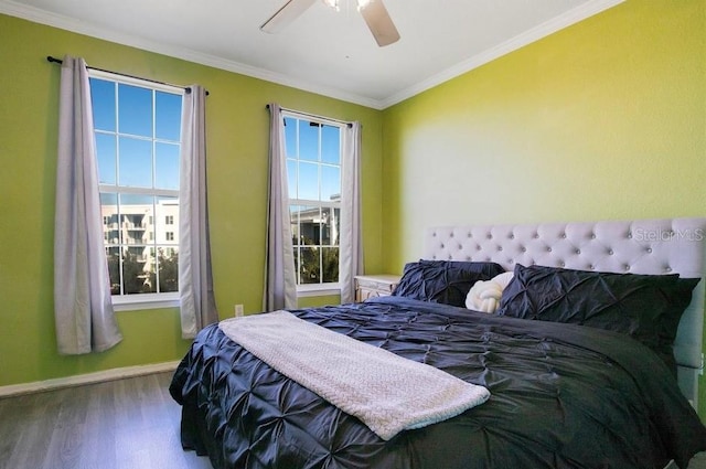 bedroom with multiple windows, hardwood / wood-style floors, crown molding, and ceiling fan