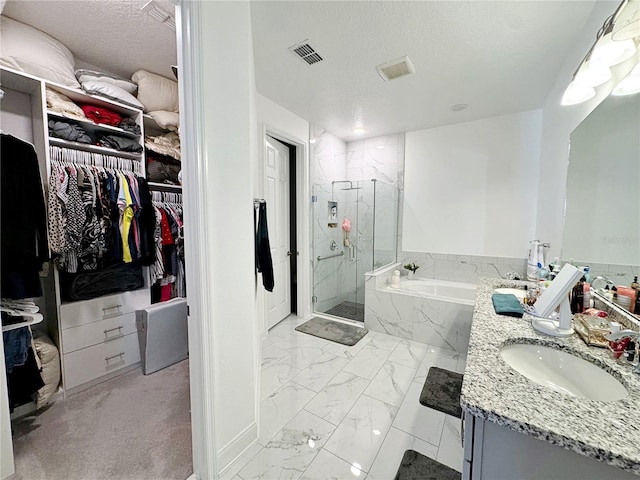 bathroom with vanity, a textured ceiling, and separate shower and tub