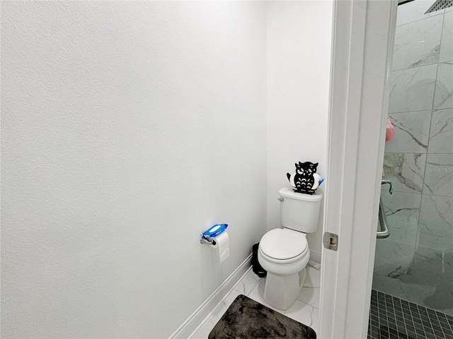 bathroom featuring tiled shower and toilet