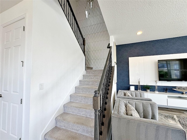 staircase featuring wood-type flooring and a textured ceiling