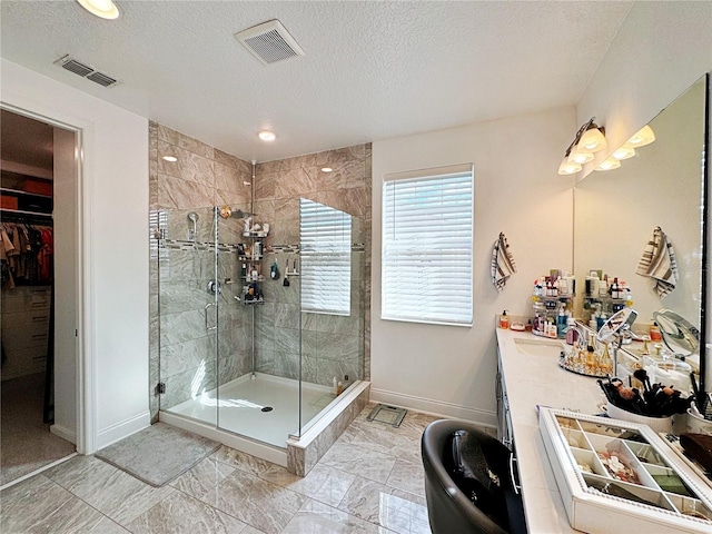 bathroom featuring vanity, an enclosed shower, and a textured ceiling