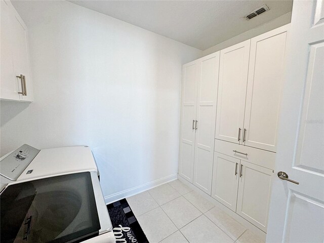 washroom with light tile patterned floors and cabinets