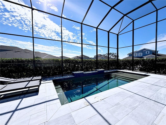 view of swimming pool featuring a patio area and glass enclosure