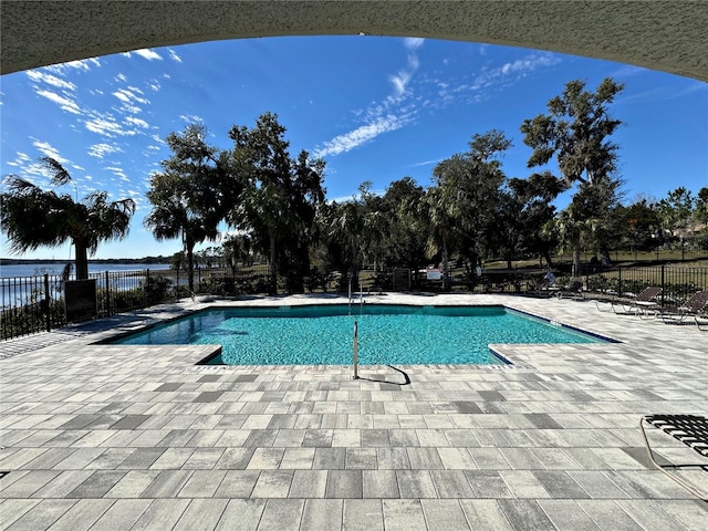 view of pool featuring a water view and a patio area