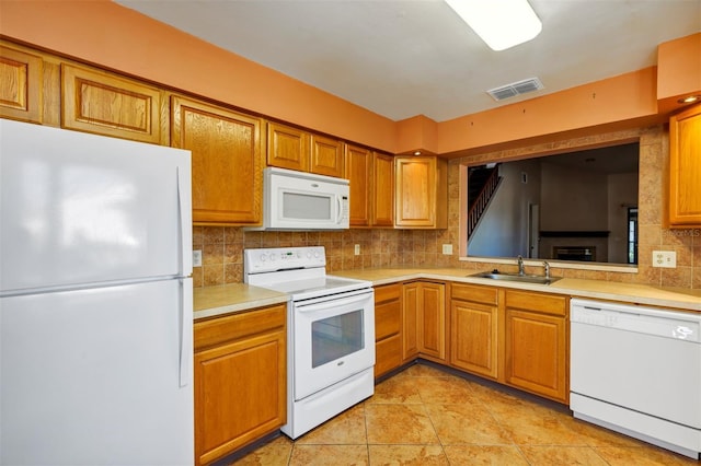 3002 Clubview Dr, Orlando, FL 32822 - kitchen with white appliances, light countertops, backsplash, and brown cabinetry