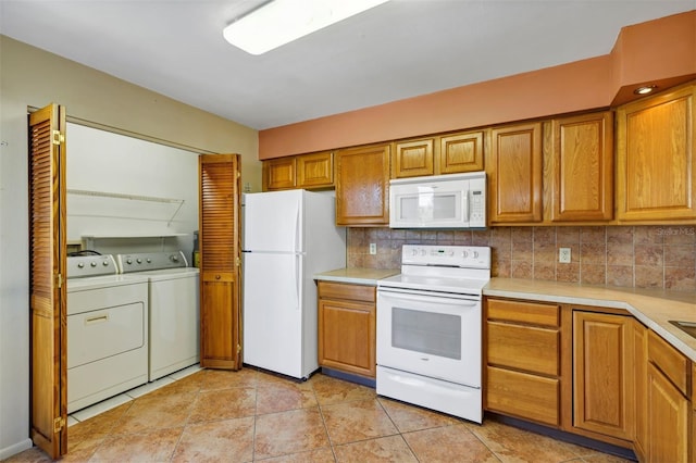 3002 Clubview Dr, Orlando, FL 32822 - kitchen featuring white appliances, washing machine and dryer, light countertops, and decorative backsplash