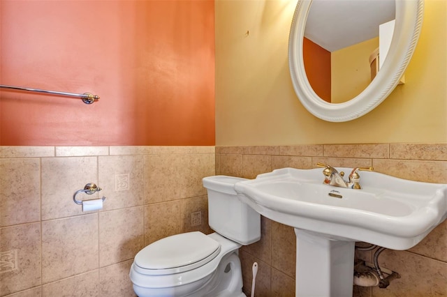 3002 Clubview Dr, Orlando, FL 32822 - half bathroom featuring toilet, tile walls, wainscoting, and a sink