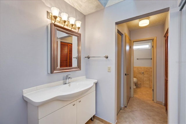 3002 Clubview Dr, Orlando, FL 32822 - bathroom featuring vanity, toilet, tile patterned floors, tile walls, and wainscoting
