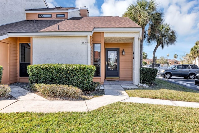3002 Clubview Dr, Orlando, FL 32822 - view of front of house featuring a front yard, roof with shingles, stucco siding, and a chimney