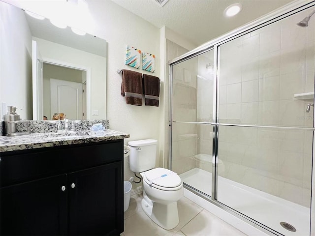 bathroom featuring toilet, a textured ceiling, a shower stall, tile patterned flooring, and vanity