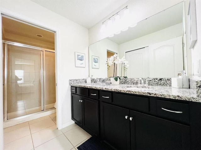 full bath featuring tile patterned flooring, a stall shower, vanity, and baseboards