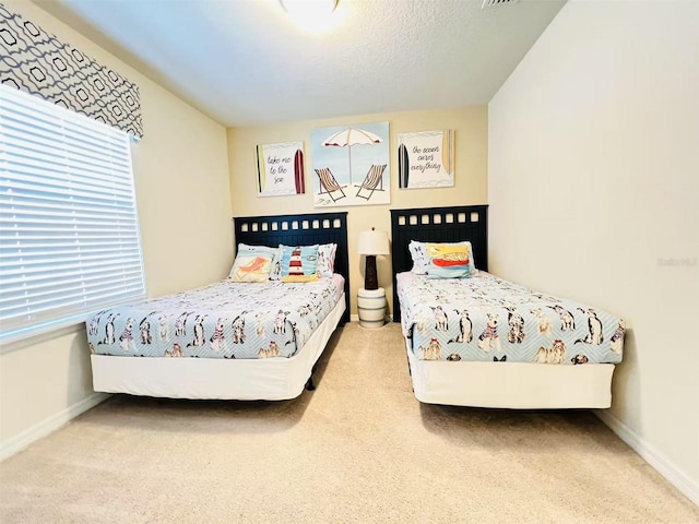 carpeted bedroom with visible vents, baseboards, and a textured ceiling