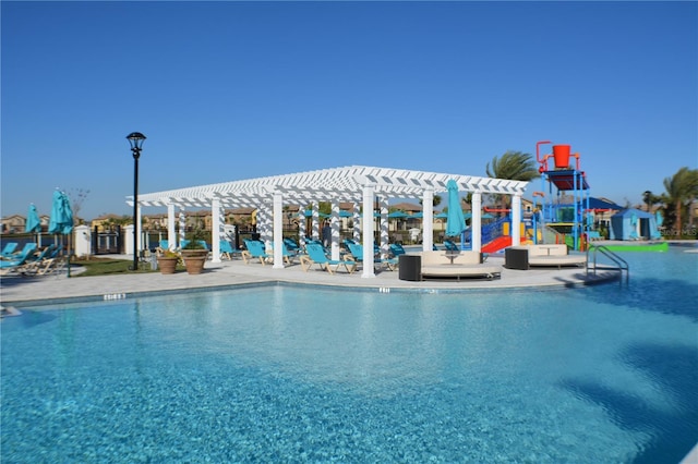 pool with a patio area, a water play area, a pergola, and playground community