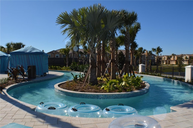 pool featuring a jacuzzi and fence