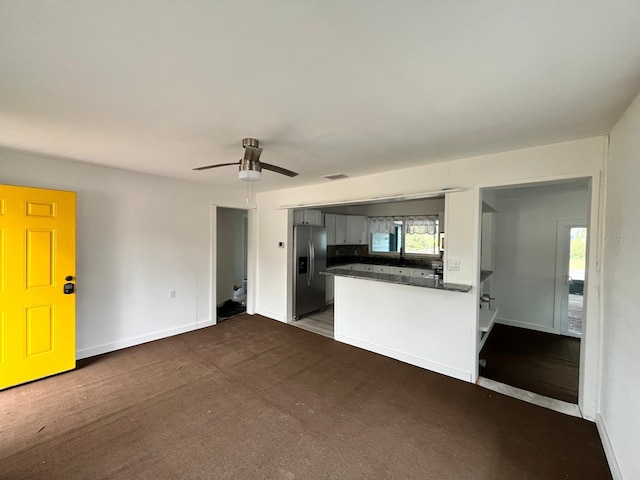 kitchen with ceiling fan, stainless steel fridge, kitchen peninsula, and dark carpet