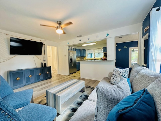 living room featuring ceiling fan and light wood-type flooring