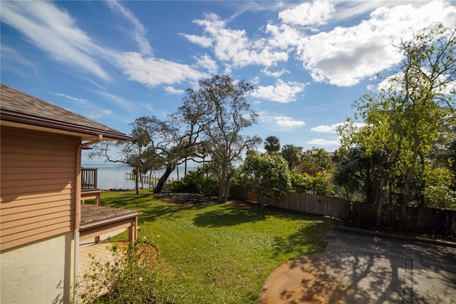 view of yard featuring a water view and fence