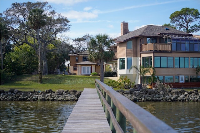 dock area featuring a water view, a yard, and a balcony