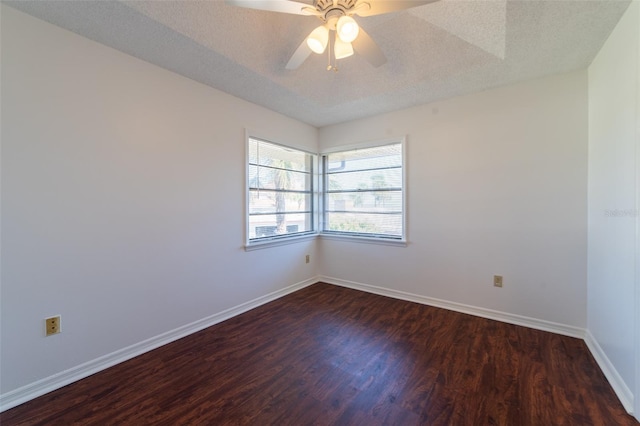 spare room featuring dark wood finished floors, a textured ceiling, baseboards, and ceiling fan