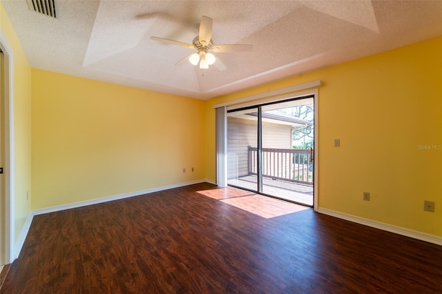 empty room with baseboards, a textured ceiling, visible vents, and wood finished floors