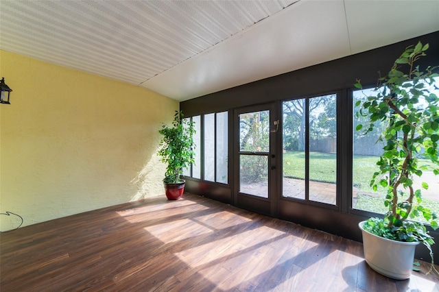 unfurnished sunroom featuring vaulted ceiling