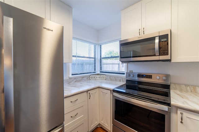 kitchen featuring light stone countertops, white cabinetry, and appliances with stainless steel finishes