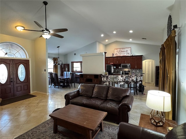 tiled living room featuring ceiling fan and vaulted ceiling