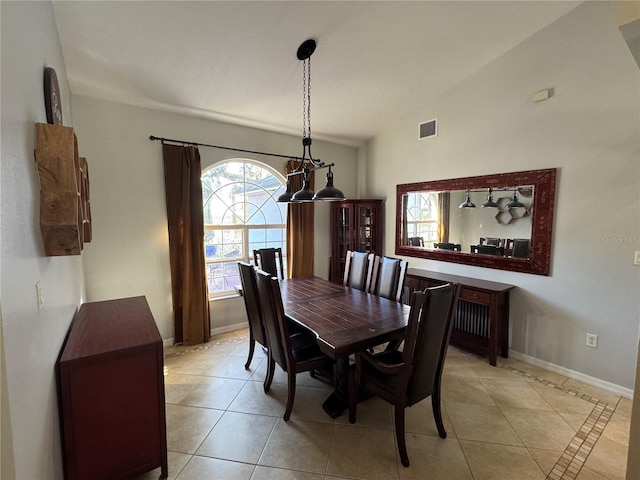 tiled dining room featuring lofted ceiling