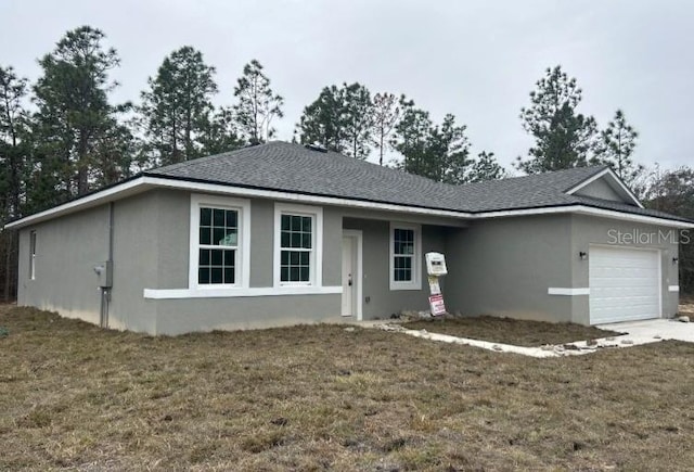 single story home featuring a garage and a front yard