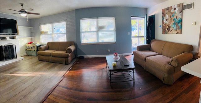 living room featuring ceiling fan, a fireplace, hardwood / wood-style floors, and a wealth of natural light