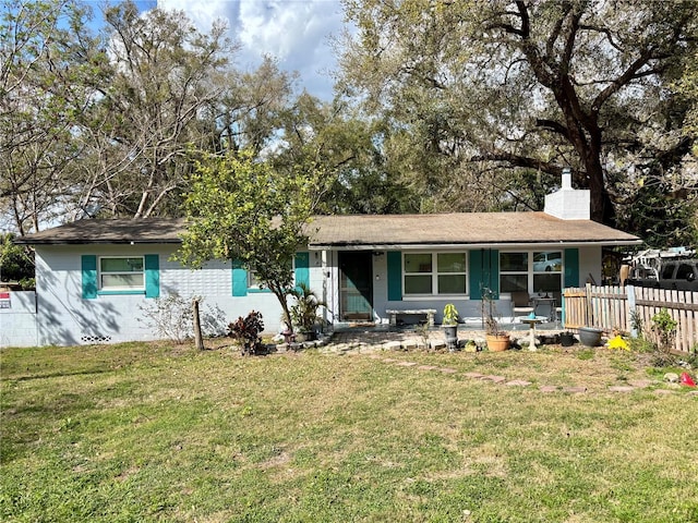 ranch-style house with a chimney, fence, and a front yard