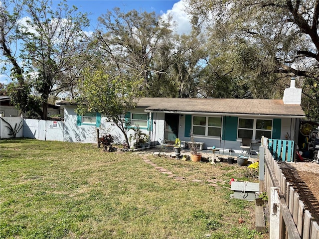 ranch-style home featuring a front yard, fence, and a chimney