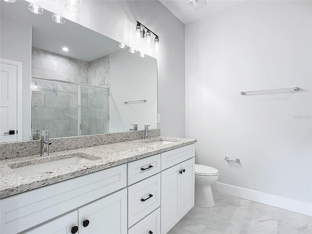 bathroom with vanity, a shower with shower door, and toilet