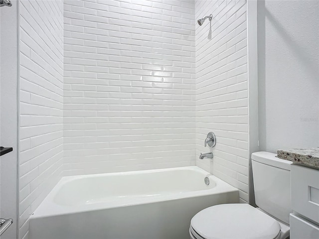 full bathroom featuring tiled shower / bath, vanity, and toilet