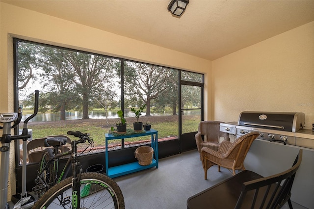 sunroom / solarium featuring a water view